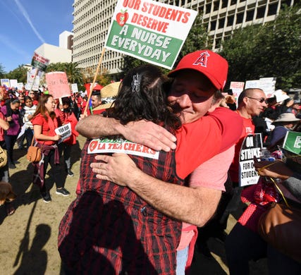 Frank Boyle hugs fellow elementary school teacher Myrna Escobedo-Hernandez at a rally turned into a celebration in Grand Park across from LA City Hall in Los Angeles.