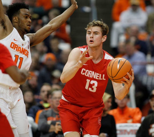 Cornell's Stone Gettings, right, looks to pass the ball under pressure from Syracuse's Oshae Brissett, left, in the second half of an NCAA college basketball game in Syracuse, N.Y., Friday, Nov. 10, 2017. (AP Photo/Nick Lisi)