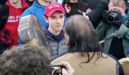 Nick Sandmann, center left, stands in front of Native American activist Nathan Phillips at a rally in Washington, D.C.