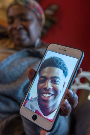 Lula Henry holds up her favorite photo of her son Evan Henry,  one of Jackson's first homicide victims of 2019. Henry, 23, was found shot to death on Jan. 1. Jackson police suspect he was a victim of a robbery.
