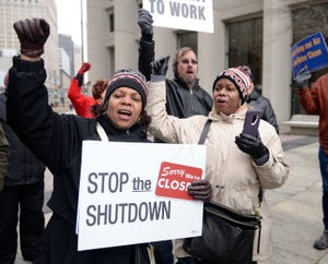 Cheryl Monroe, left, of Ecorse, an FDA employee and her sister Sheila Monroe, right, of Fort Mill, South Carolina, a Department of Treasury employee, chant "Call a vote" along with other furloughed workers during an anti-government shutdown rally in downtown Detroit in this Jan. 21, 2019 file photo.