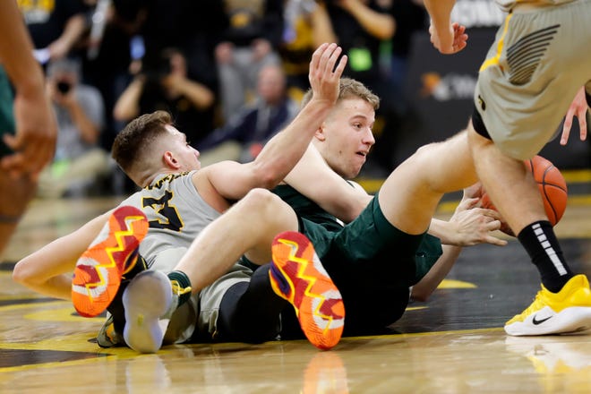 Michigan State forward Thomas Kithier fights for a loose ball with Iowa guard Jordan Bohannon, left.