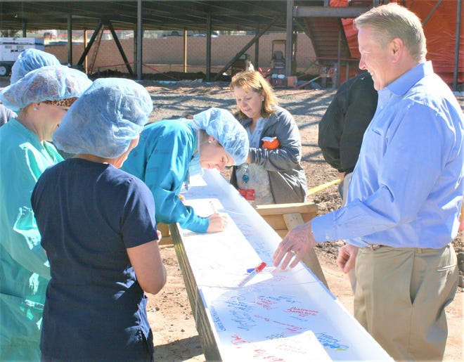Hospital administrator Todd Oberheu and staff sign the beam.