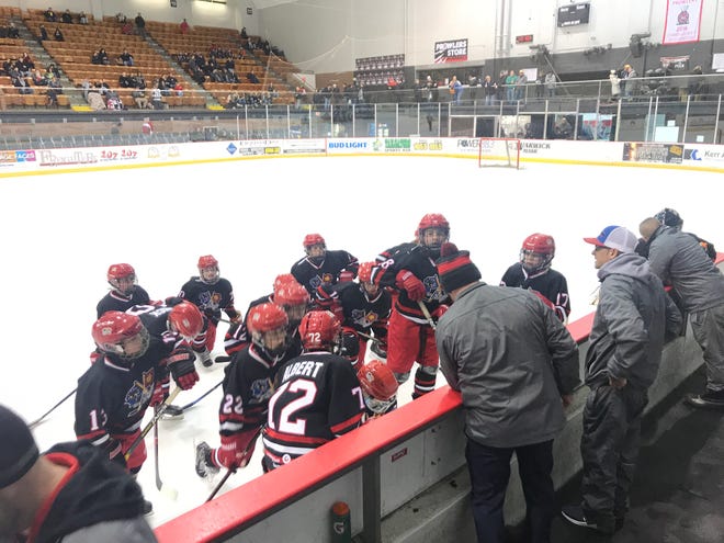 The Port Huron Flags PeeWee AA team talks during its first intermission Friday at McMorran Arena.