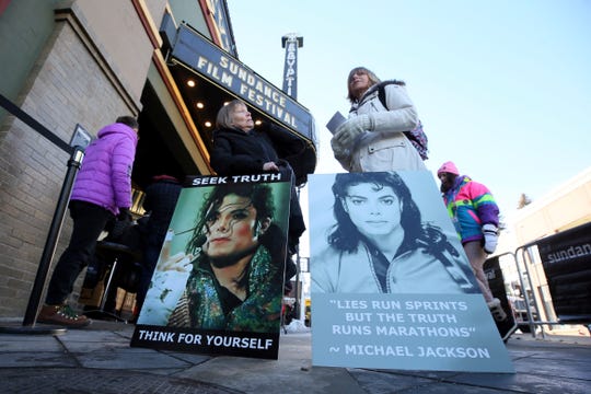 Brenda Jenkyns, left, and Catherine Van Tighem, who drove from Calgary, Canada, stand with signs outside of the premiere of 'Leaving Neverland' at Sundance Film Festival.