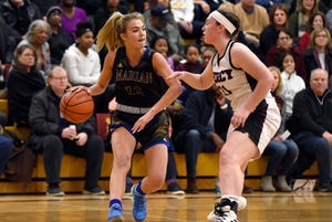 Birmingham Marian guard Olivia Moore (12) is guarded by Farmington Hills Mercy guard Annie Treharne (31) during the first quarter.