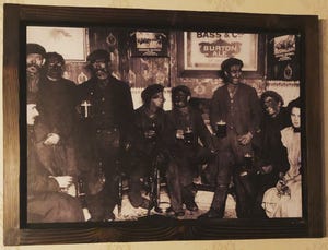 The photo of men covered in soot, drinking at a pub, framed on the wall of  a downtown Phoenix restaurant.
