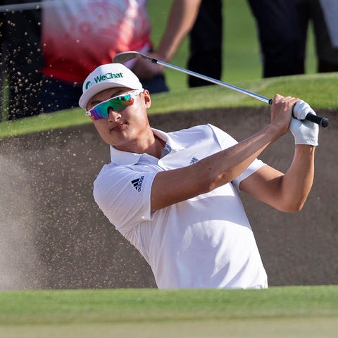 Haotong Li of China chips out of a bunker on the...