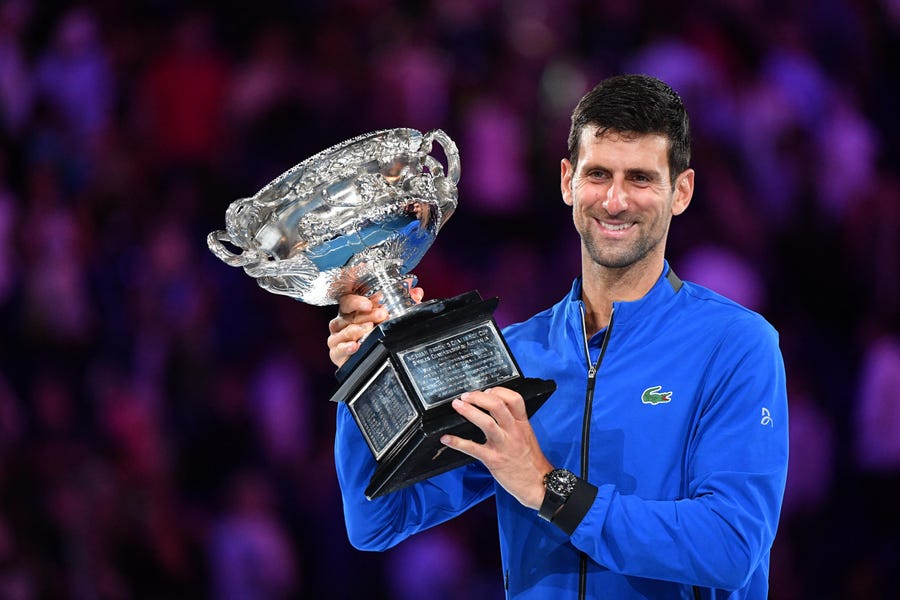 Novak Djokovic celebrates with the trophy after winning his seventh Australian Open singles championship.