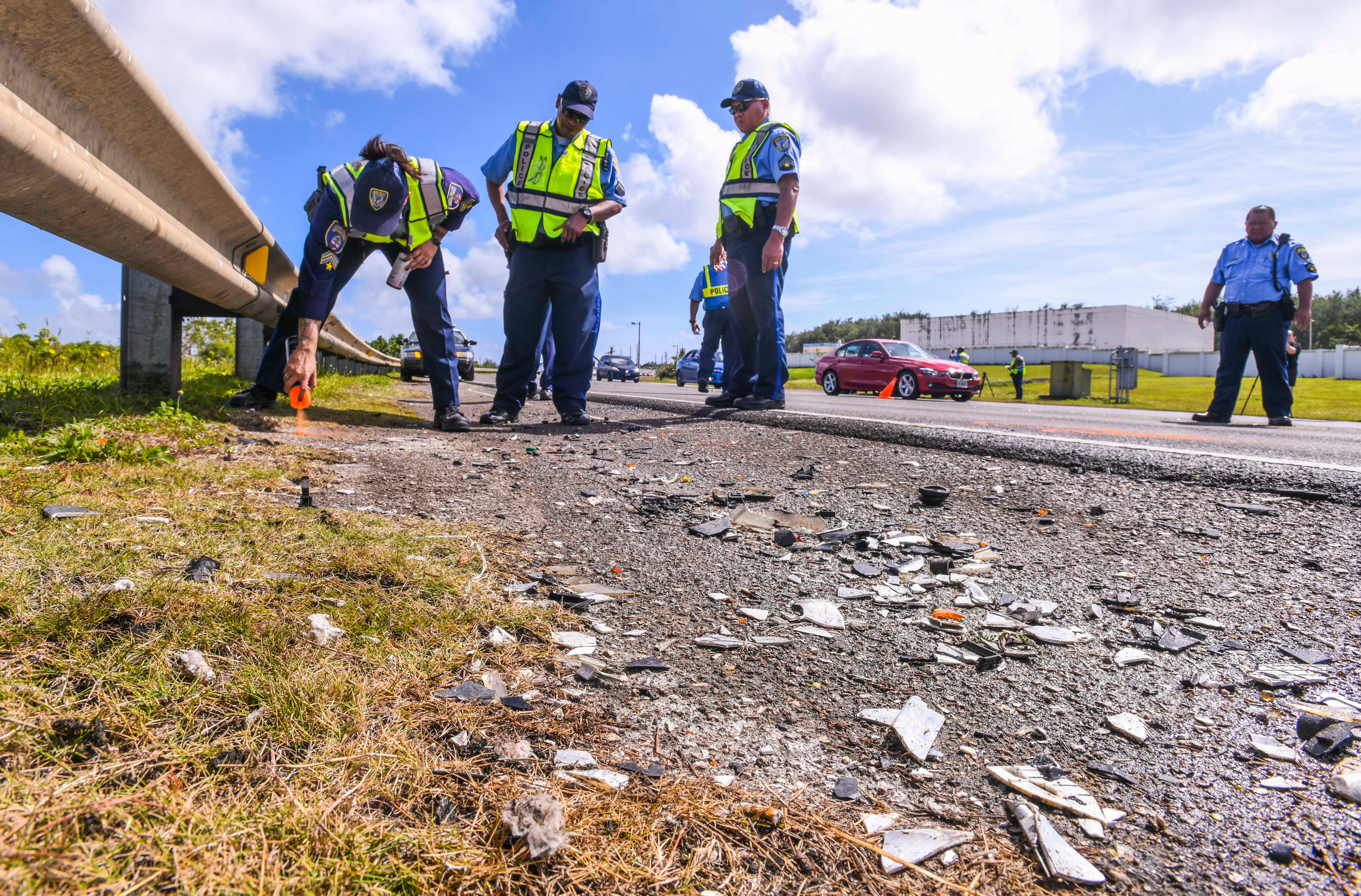 In this Jan. 9, 2019, file photo, Guam Police Department officer Morgan Reyes marks key points of interest as she and other Highway Patrol Division officers conduct a traffic accident investigation along Route 10A.