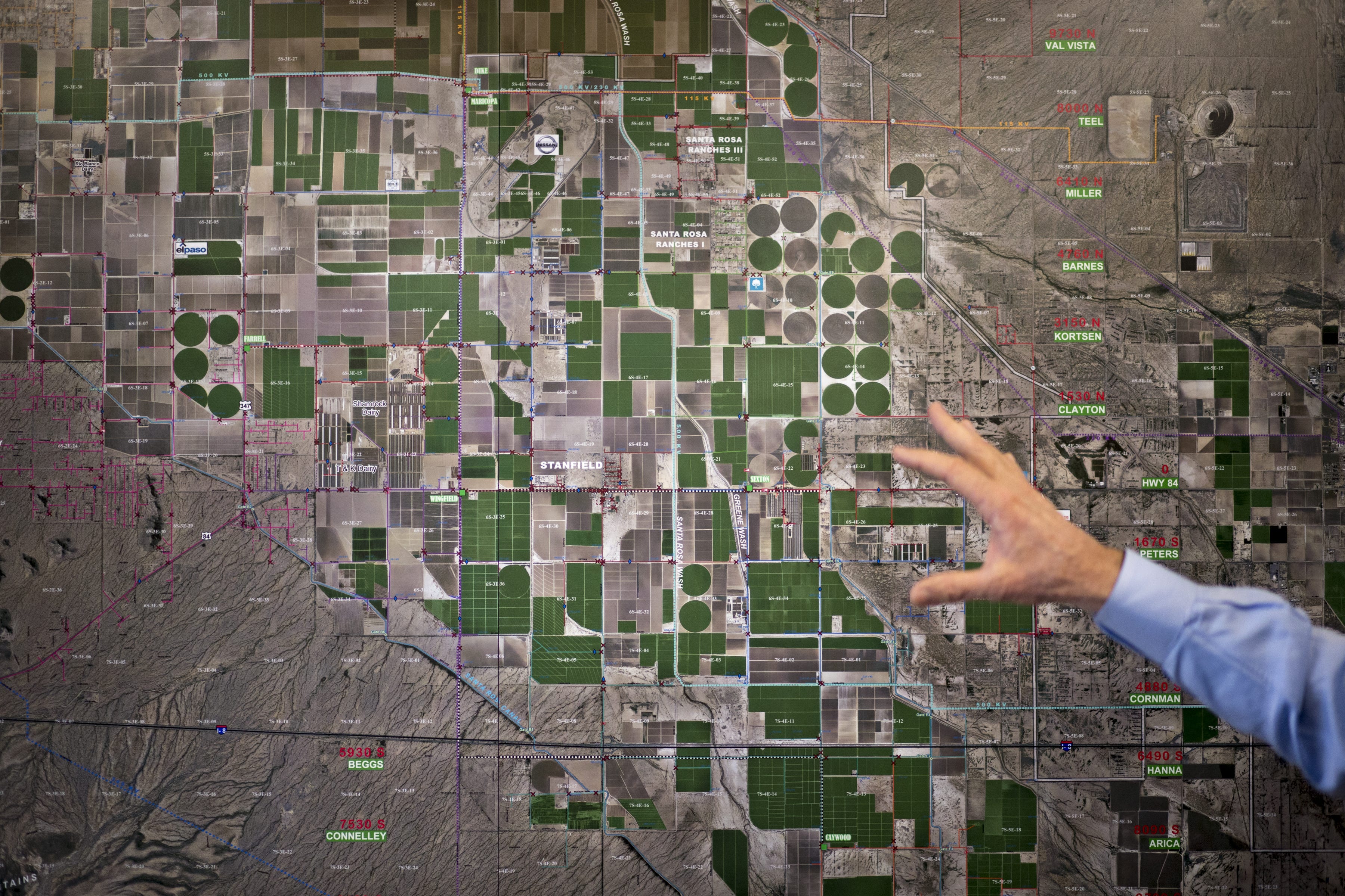 Farmer Dan Thelander motions to an aerial photo of farmland at the office of the Maricopa-Stanfield Irrigation District in Pinal County.