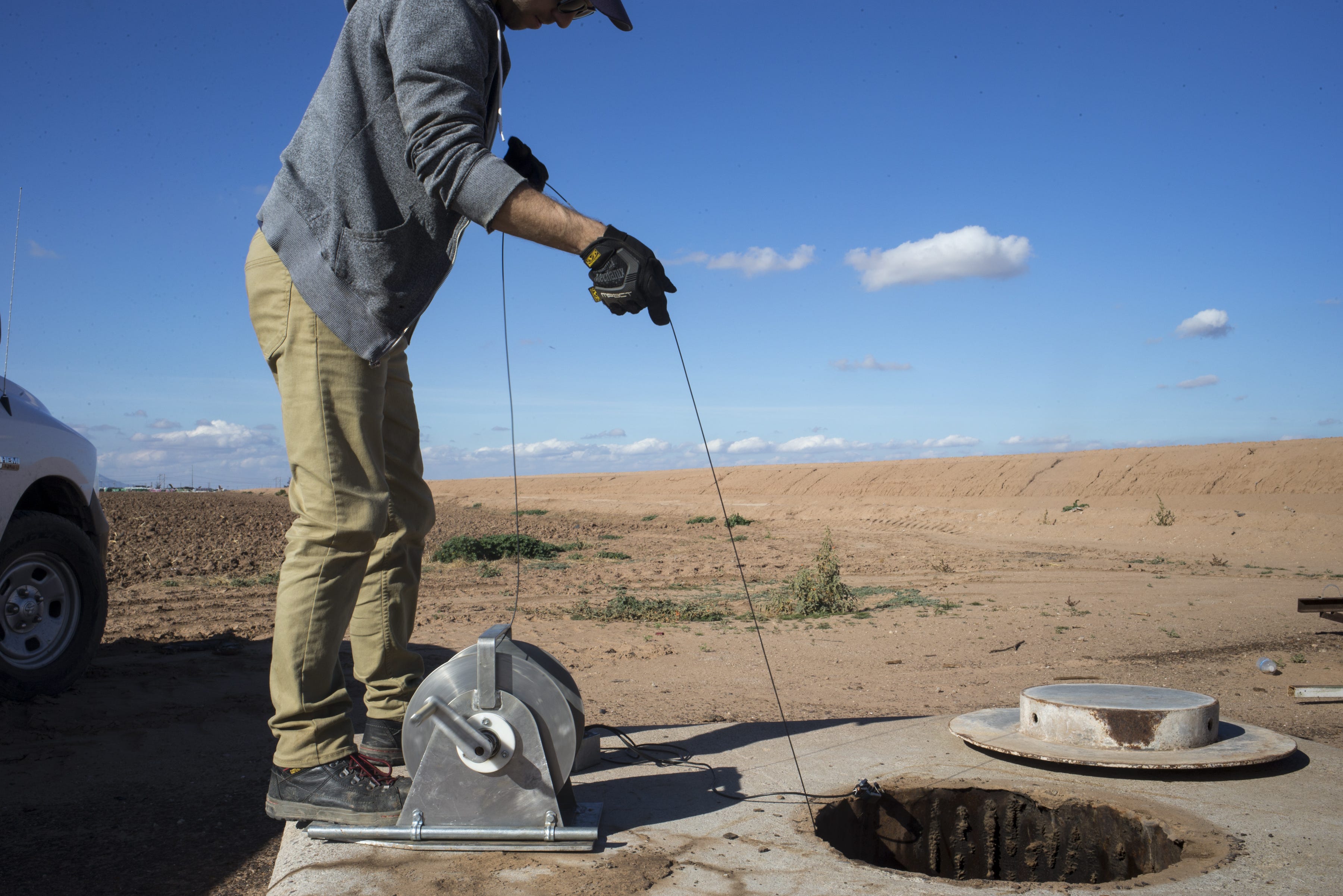 Scott Stuk of the Arizona Department of Water Resources drops a probe down an unused well to measure the groundwater level south of Maricopa. The water was 280 feet down.