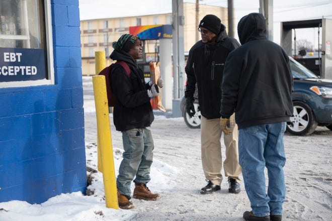 Case worker Herbert Morris, center, and transportation manager Michael Colbert, right, ask a homeless man named Danny to come with them to a Detroit Rescue Mission Ministries shelter, while panhandling at a gas station at Harper and Connor, in Detroit, January 29, 2019.  Danny refused to go to the shelter.