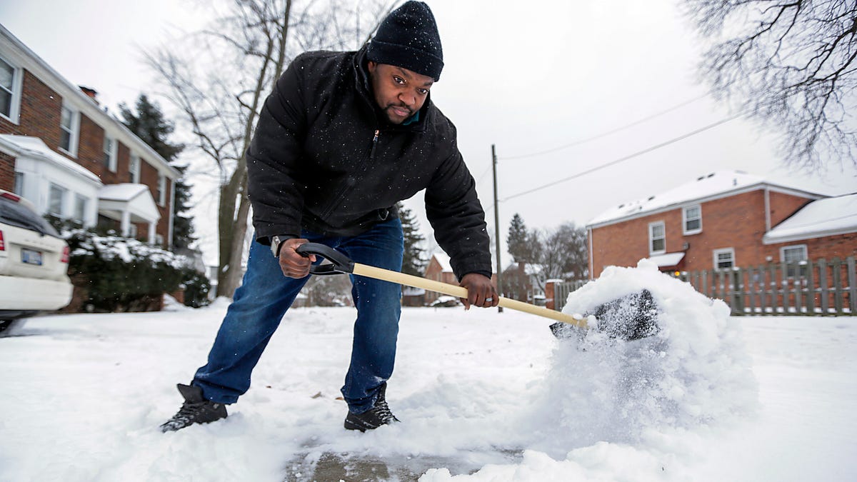 On the eve of the Polar Vortex, David Collins, 36, clears the snow from the walkways and driveway in front of his home in Detroit Jan. 29, 2019