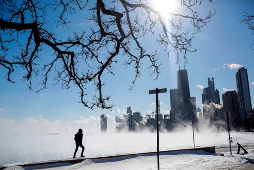 Marius Radoi observa mientras el vapor flota sobre el lago Michigan cuando las temperaturas bajaron a -20 grados F (-29 ° C) el 30 de enero de 2019 en Chicago, Illinois.