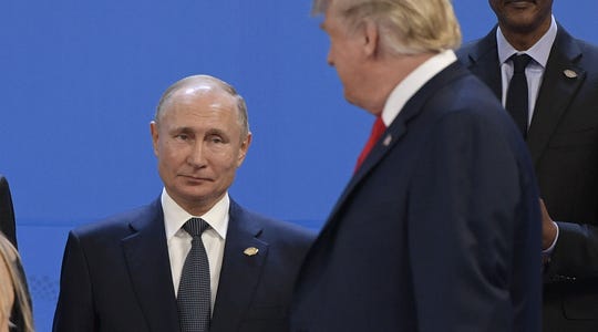 President Donald Trump, looks at Russia's President Vladimir Putin as they prepare for a group photo, during the G-20 Leaders' Summit in Buenos Aires, on Nov. 30, 2018.