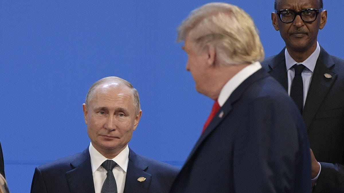 President Donald Trump, looks at Russia's President Vladimir Putin as they prepare for a group photo, during the G-20 Leaders' Summit in Buenos Aires, on Nov. 30, 2018.
