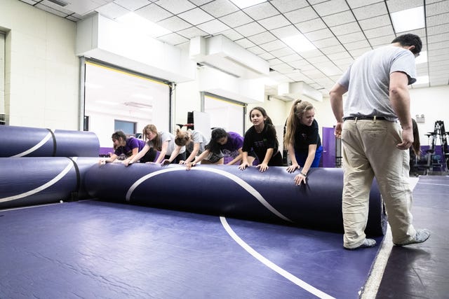 Some of the members of Relentless Wrestling, the first and only all-women's wrestling club in North Carolina, roll up a mat at the end of practice at Apple Valley Middle School in Hendersonville, Jan. 31, 2019.