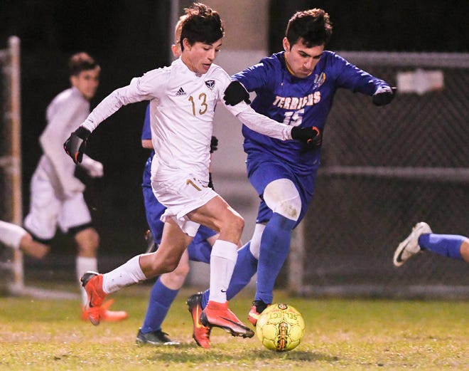 Eau Gallie's Jaxon Supernaw is closely guarded by Mickey Mikitarian of Titusville during a district tournament game.