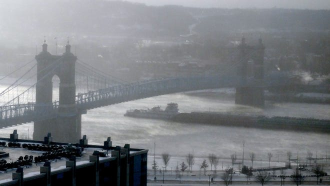 A barge passed under the Roebling Suspension Bridge on the Ohio River Wednesday.