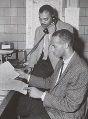 Attucks coach Bill Garrett (front) looks over scouting reports on the Madison Cubs, the opponent in the 1959 semistate tournament, while Ray Crowe, Athletic Director Ray Crowe answers the phone.  March 11, 1959