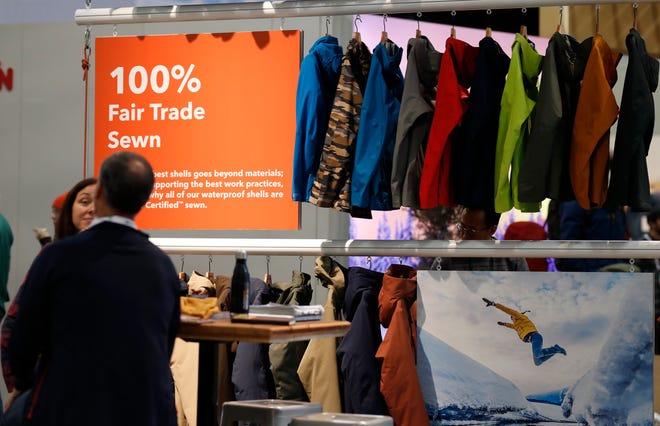 In this Wednesday, Jan. 30, 2019, photograph, a sign indicating items that were 100-percent fair trade-sewn marks a rack of jackets and shells in the Patagonia exhibit at the Outdoor Retailer & Snow Show in the Colorado Convention Center in Denver. Major players in the outdoor industry jumped into the political fight over national monuments two years ago and now have added climate change and sustainable manufacturing to their portfolio. (AP Photo/David Zalubowski)