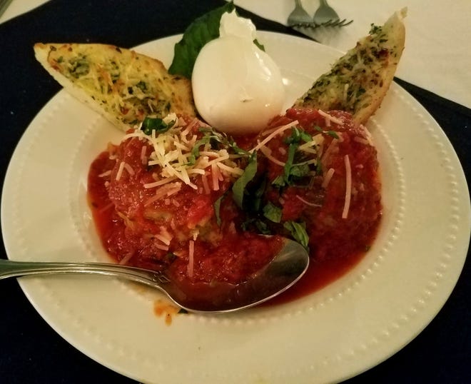 The meatballs and burrata appetizer at 18 Seminole Street consists of two tender meatballs in a fragrant tomato sauce served with creamy burrata cheese and garlic toast points.