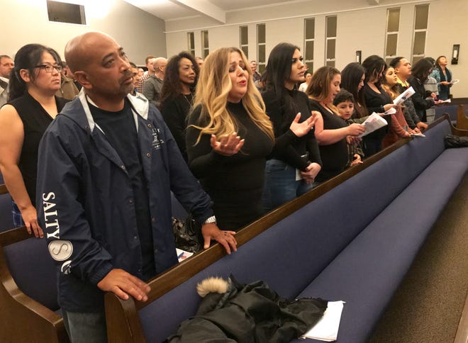 Family members of Ventura County Rescue Mission graduate JR Gutierrez sing during a ceremony to mark the occasion Jan. 29, 2019, in Oxnard.