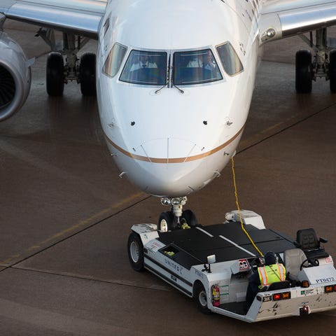 A United Express Embraer E175 is pushed back from...