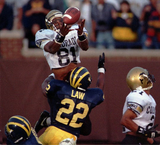 Colorado's Michael Westbrook reaches over Michigan's Ty Law to make the winning catch with no time left in Colorado's 27-26 win in Ann Arbor, Sept. 24, 1994. The 64-yard Hail Mary pass from QB Kordell Stewart was tipped by another player before Westbrook made his catch.