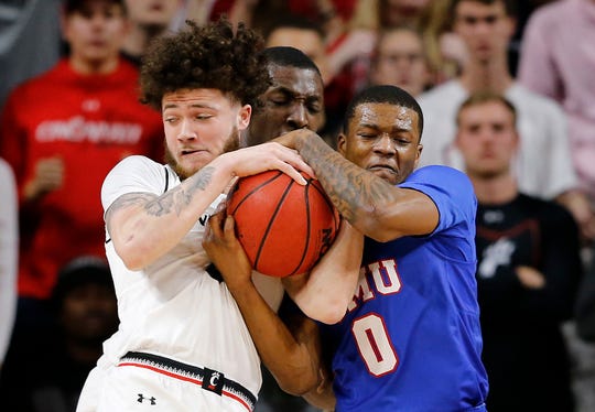 Cincinnati Bearcats guard Logan Johnson (0) wrestles with Southern Methodist Mustangs guard Jahmal McMurray (0) for the ball in the first half the the NCAA American Athletic Conference basketball game between the Cincinnati Bearcats and the Southern Methodist Mustangs at Fifth Third Arena in Cincinnati on Saturday, Feb. 2, 2019.