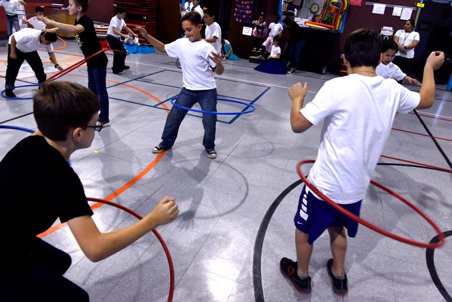 Third-grade boys hula hoop in the Austin Elementary School gymnasium Jan. 25 as part of Fifties Day. Students from all grades also performed the Twist, the Stroll and the Hand Jive for family and friends.