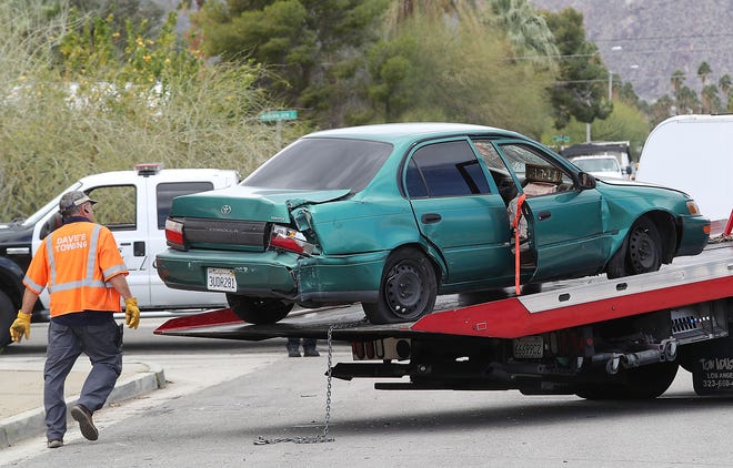 The Toyota Corolla that held three of the four victims in a slaying is towed away from Sunny Dunes Road in Palm Springs, Feb. 4, 2019.