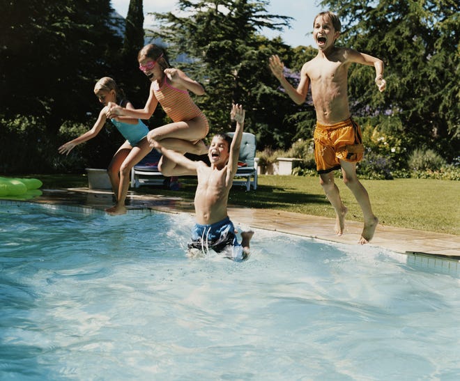 Four Young Teens Jumping in a Swimming Pool