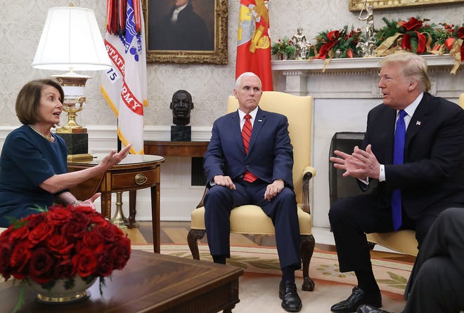 President Donald Trump is pictured speaking with House Minority Leader Nancy Pelosi (D-CA) as Vice President Mike Pence (center) sits nearby in the Oval Office.