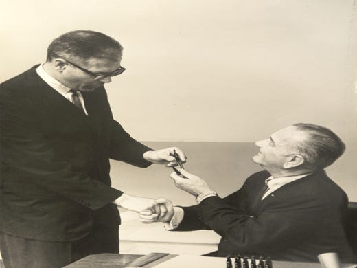 Dingell kept a personal and professional photo archive in his office, including this photo of President Lyndon Johnson handing him a pen after signing a bill.