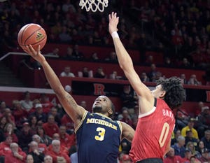 Michigan's Zavier Simpson drives to the rim against Rutgers' Geo Baker in Tuesday's 77-65 win.