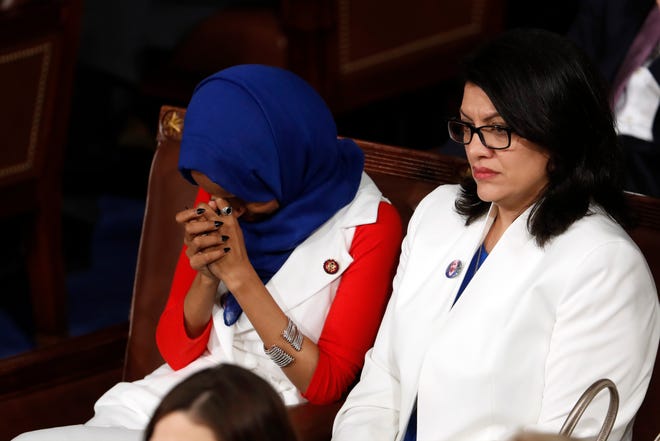 Rep. Ilhan Omar, D-Minn., left, and Rep. Rashida Tlaib, D-Mich., right, listen as President Donald Trump delivers his State of the Union address to a joint session of Congress on Capitol Hill in Washington, Tuesday, Feb. 5, 2019.