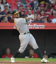 Athletics left fielder Khris Davis  watches his two-run home run clear the fence during a game against the Angels at Angel Stadium of Anaheim.
