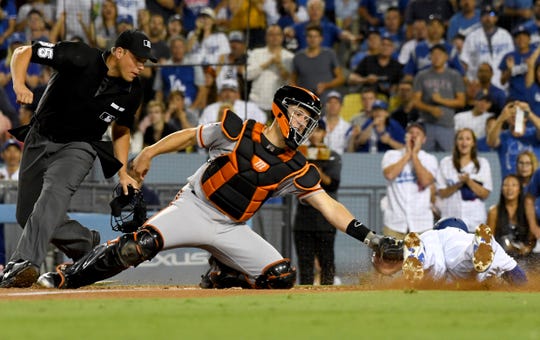 Giants catcher Buster Posey tags out Dodgers second baseman Brian Dozer during a game at Dodger Stadium.