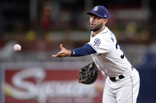 Padres first baseman Eric Hosmer tosses the ball to first base for a force out during a game against the Giants at Petco Park.