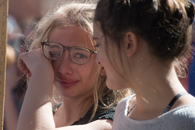 Bella Swanson, 13, wipes a tear away as she looks to her friend Bonnie Torres during a March for Our Lives event on on March 24, 2018. The gathering was a part of the national movement following the Parkland, Fla., shooting.