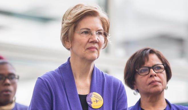 Sen. Elizabeth Warren, D-Mass., listens during a rally for airport workers affected by the government shutdown at Boston Logan International Airport on Jan. 21, 2019 in Boston, Massachusetts.