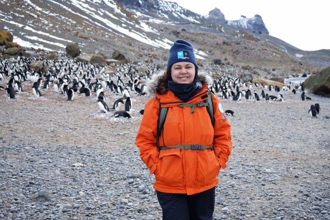 Santa Teresa High School science teacher Monica Nuñez, during her 2017-18 trip to Antarctica, flanked by penguins.