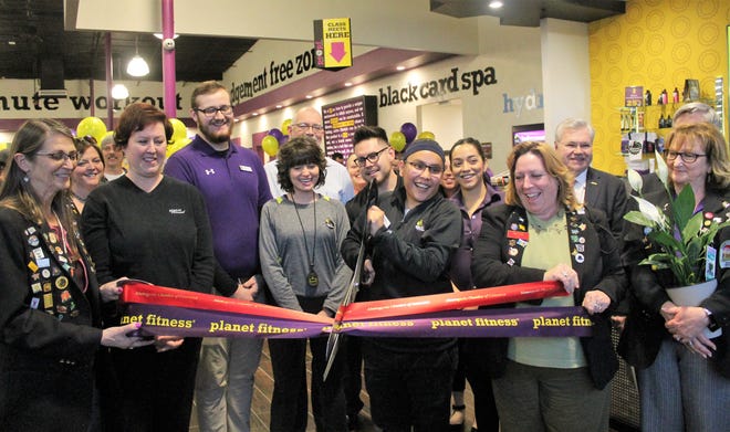 Planet Fitness Manager Nicole Lesansee , center, cuts the ribbons marking Planet Fitness' grand opening Wednesday.