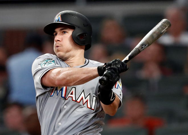 FILE - In this Tuesday, Aug. 14, 2018 file photo, Miami Marlins' J.T. Realmuto follows through on two-run base hit in the fourth inning of a baseball game against the Atlanta Braves in Atlanta. A person familiar with the negotiations says Miami Marlins All-Star catcher J.T. Realmuto has been traded to the Philadelphia Phillies for catcher Jorge Alfaro, two pitching prospects and international bonus pool allocation. The person confirmed the trade to The Associated Press on condition of anonymity Thursday, Feb. 7, 2019 because the teams had not announced it. (AP Photo/John Bazemore, File)