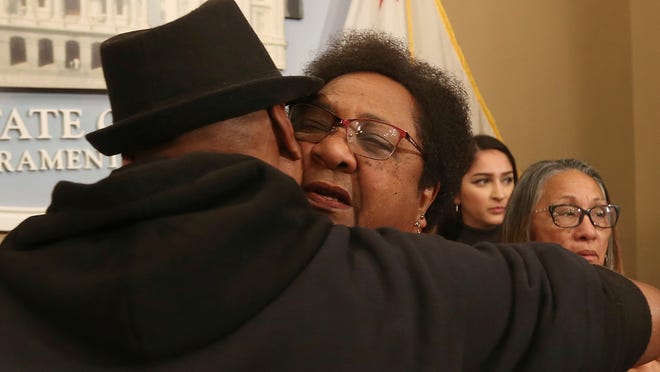 Assemblywoman Shirley Weber, D-San Diego, right, is hugged by Cephus Johnson, the uncle of Oscar Grant, who was killed by BART police n 2009. Weber announced a bill that would allow police to use deadly force only when there is no reasonable alternative.