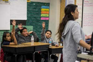 Third grade students raise their hands in Erica Kurz's class on Thursday, Feb. 7, 2019, at Longfellow Elementary in Mesa, Ariz. A new bill going through the legislature would change how much mandated instruction time ELL students receive, and would curb unintended consequences like segregated recess and lunch periods.