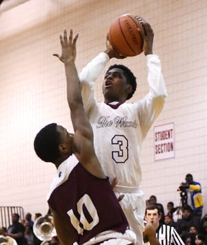 Harper Woods' Curtis Jackson puts up a shot over River Rouge's Bralin Toney in the first half.