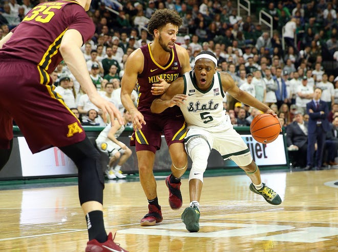 Feb 9, 2019; East Lansing, MI, USA; Michigan State Spartans guard Cassius Winston (5) drives the lane against Minnesota Golden Gophers guard Gabe Kalscheur (22) during the second half at the Breslin Center. Mandatory Credit: Mike Carter-USA TODAY Sports